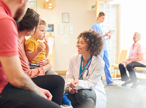 Geluidsisolatie verhindert geluidsoverlast in de dokterspraktijk of het advocatenkantoor Een arts in een dokterspraktijk met geluidsisolatie in gesprek met een familie.
