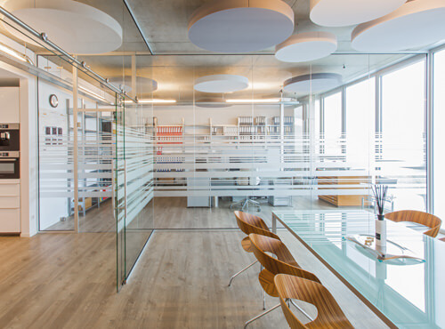 Kantoor met absorptieplaten Ronde absorptieplaten aan het plafond van een kantoor verbeteren de ruimteakoestiek.