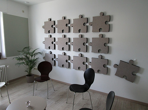 Absorptieplaten in de wachthoek Absorptieplaat in de vorm van een puzzel, in de wachtkamer van een praktijk
